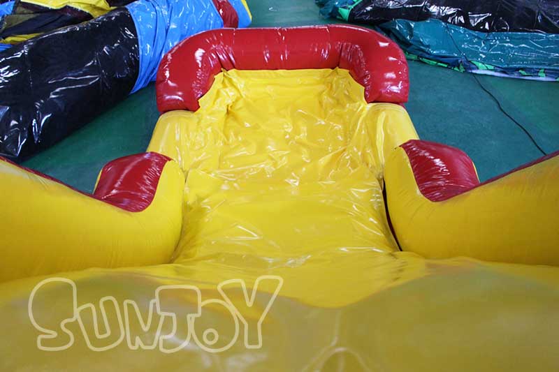 bright yellow water slide with splash pool