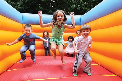 children are jumping on a bounce house